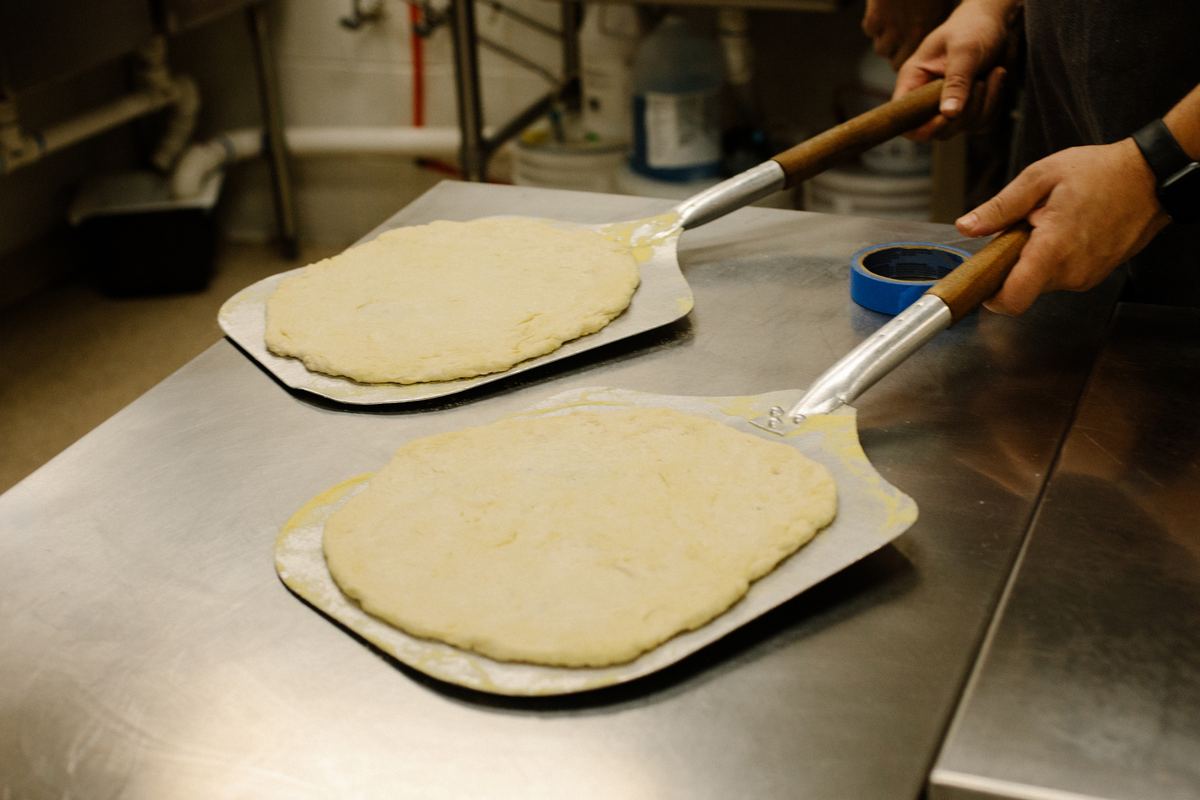 Pizza dough being prepared by hand at Amici